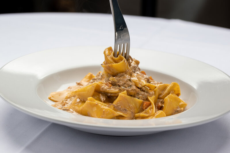 Duck pappardelle entree being twirled with a fork