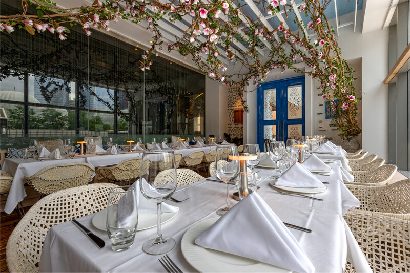 Long tables set for private party with flowers hanging from ceiling